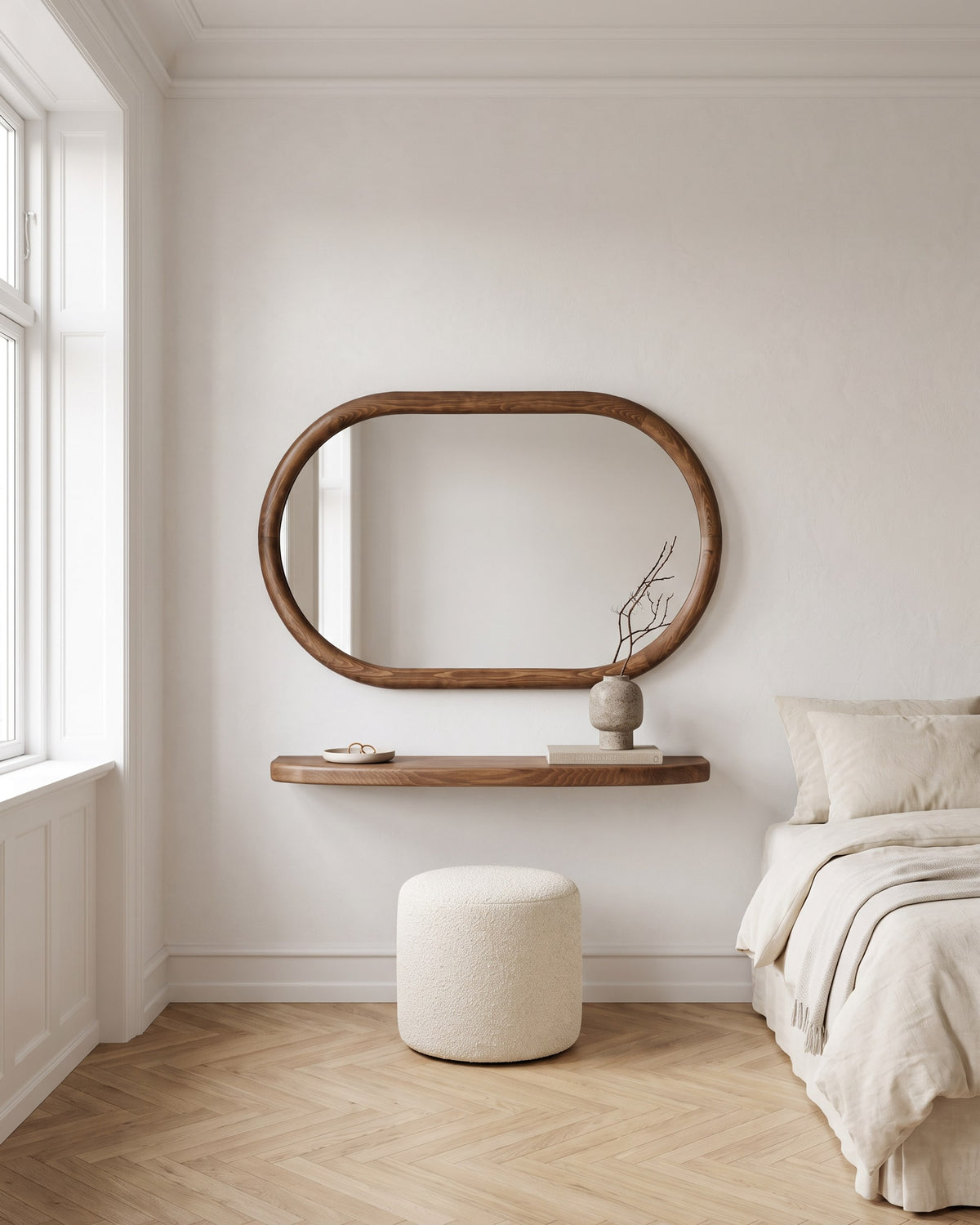 Livia oval mirror with floating walnut shelf used as a vanity in a calm bedroom with a boucle stool