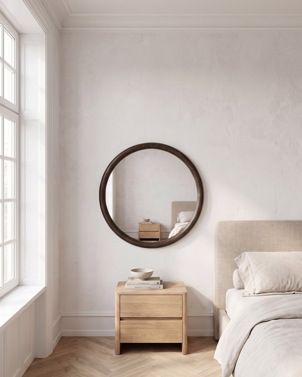 Enso round wooden mirror Ø 70 cm above an oak bedside chest in a calm bedroom