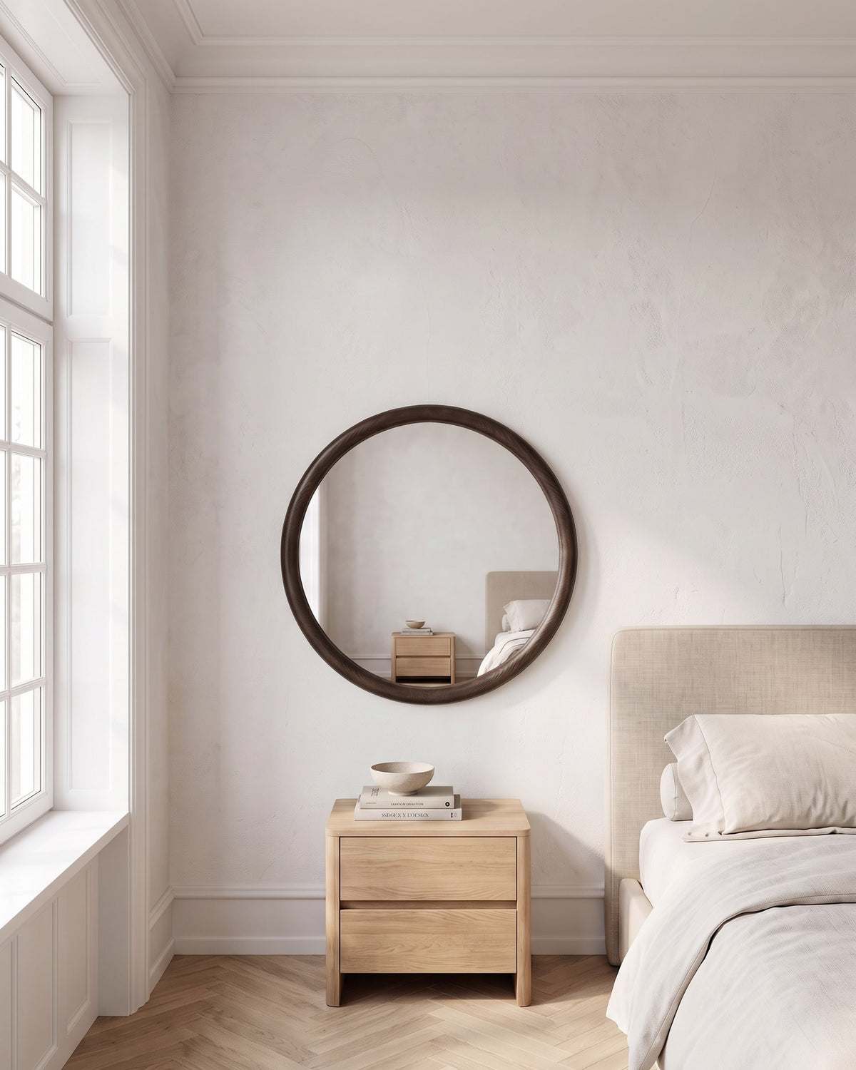 Enso round wooden mirror Ø 70 cm above an oak bedside chest in a calm bedroom