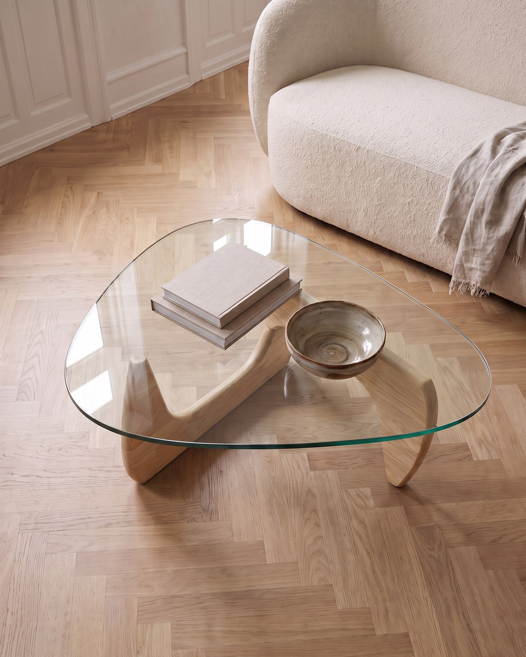 Elara oak coffee table seen from above, light wooden base visible through the clear glass top