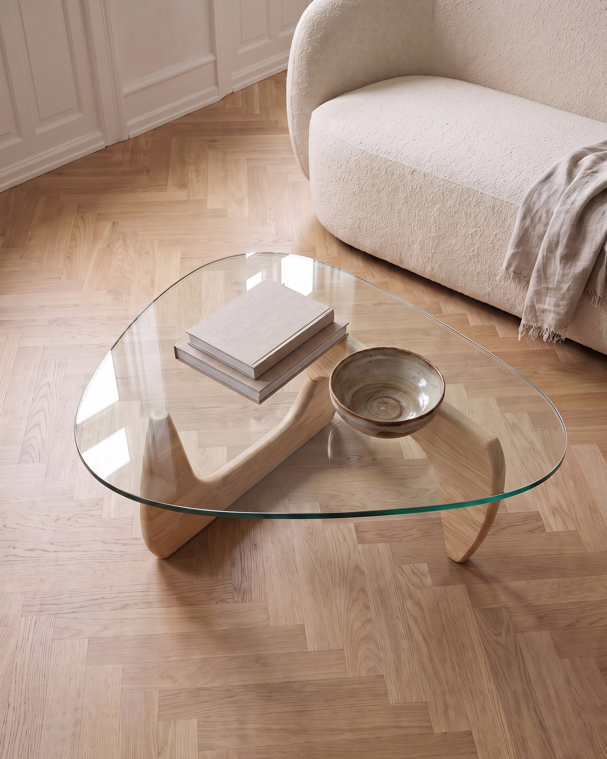Elara oak coffee table seen from above, light wooden base visible through the clear glass top