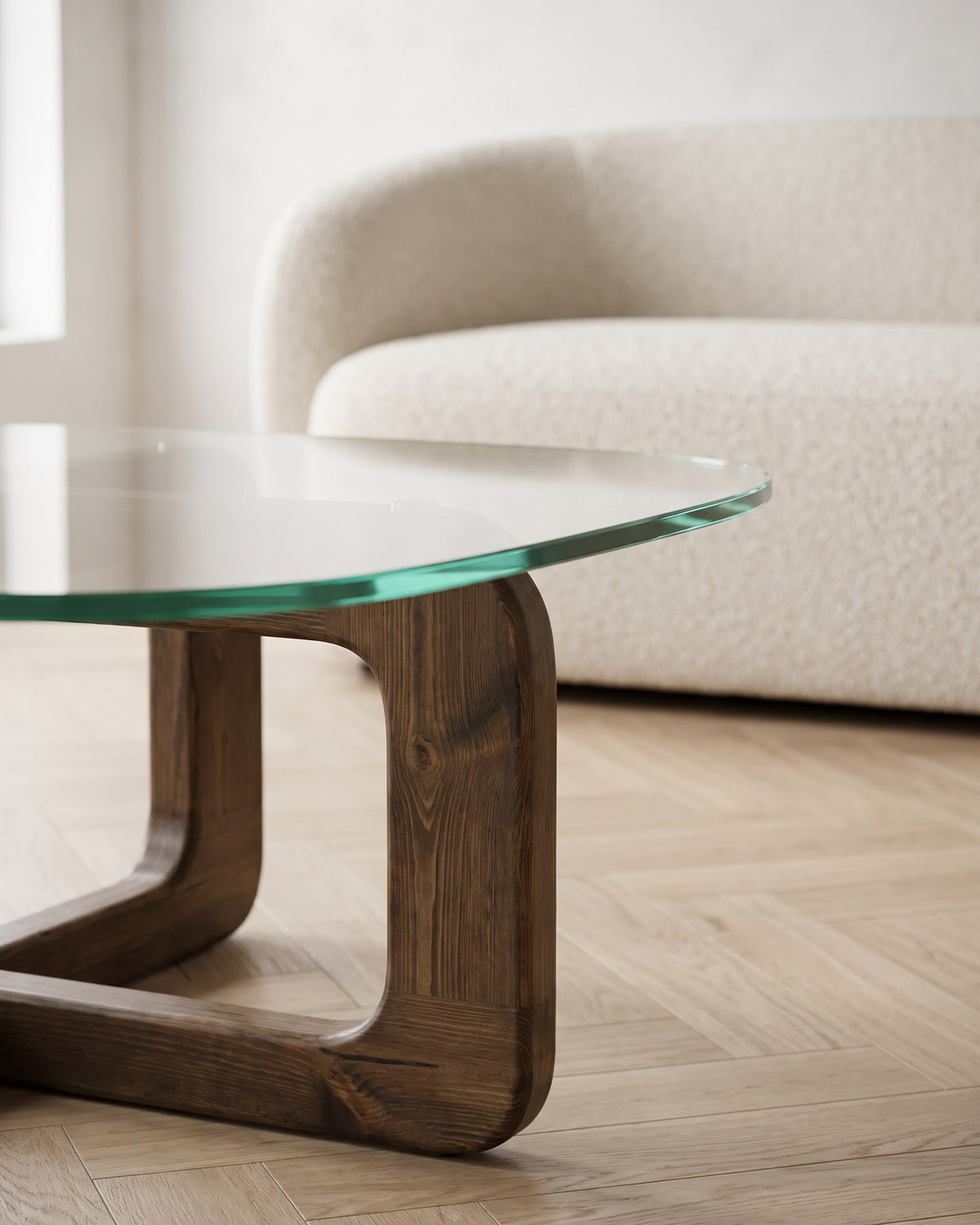 Close-up of the rounded glass corner resting on the walnut-finish loop leg of the Vesta coffee table