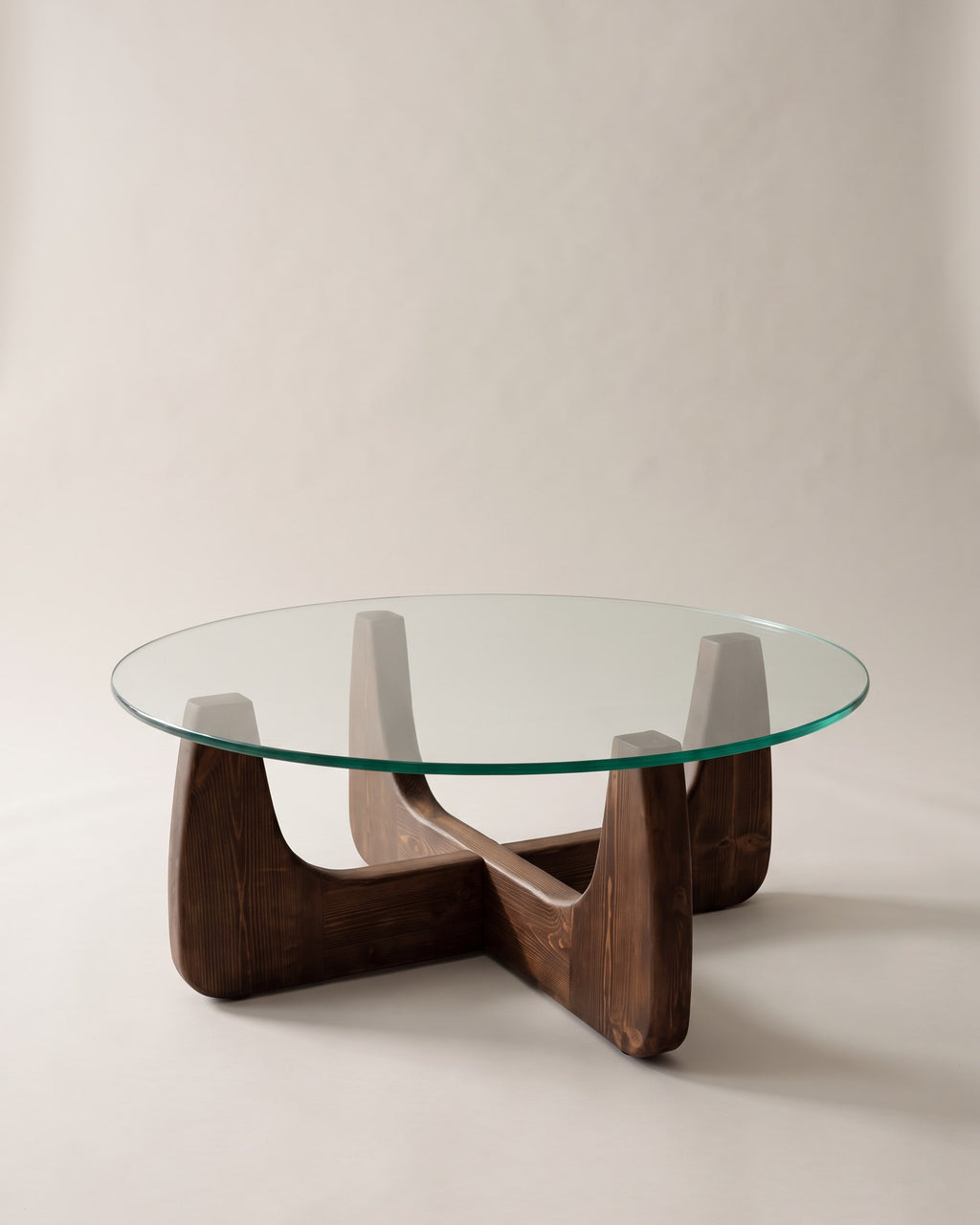 Selene round coffee table with walnut-finish base on a plain greige studio background