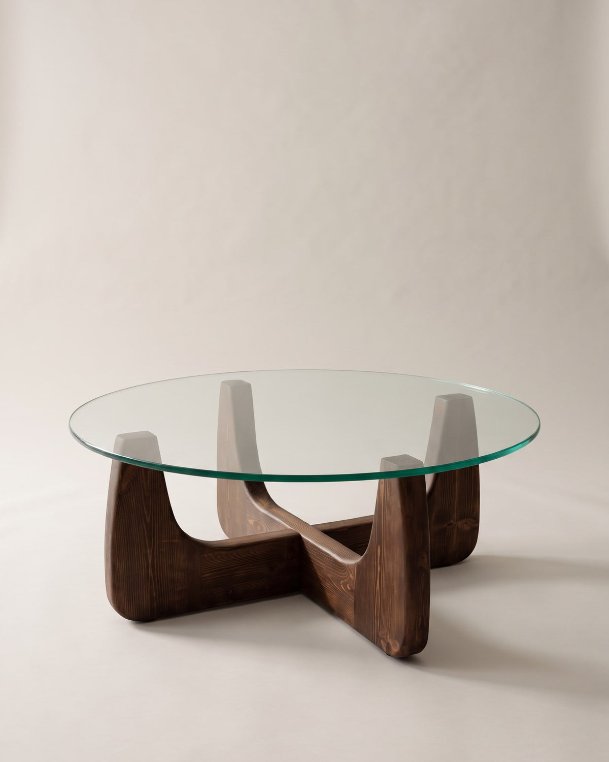 Selene round coffee table with walnut-finish base on a plain greige studio background