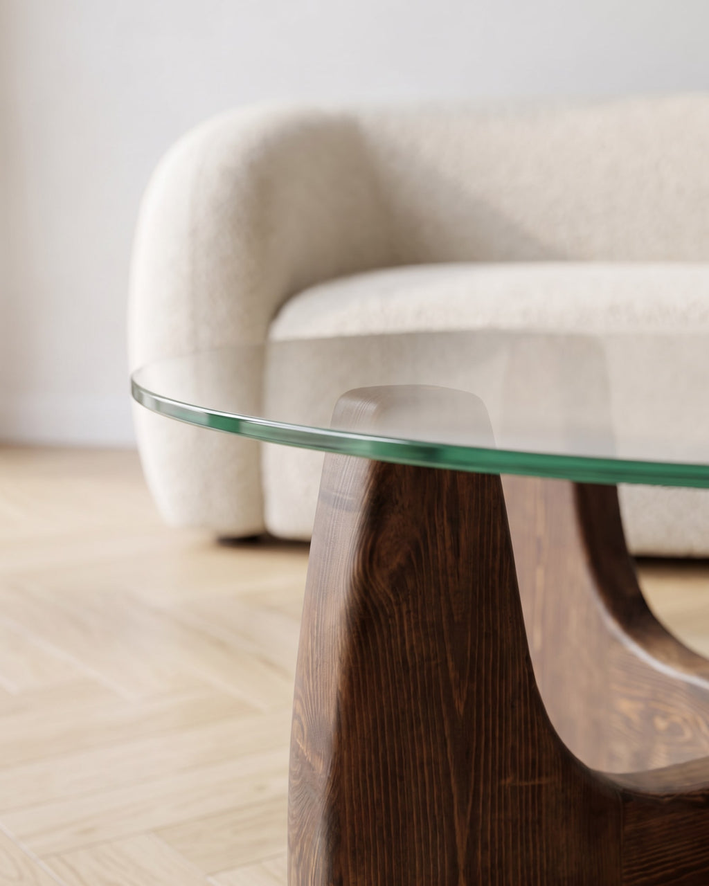 Close-up of the round glass top resting on the walnut-finish wooden base of the Selene coffee table