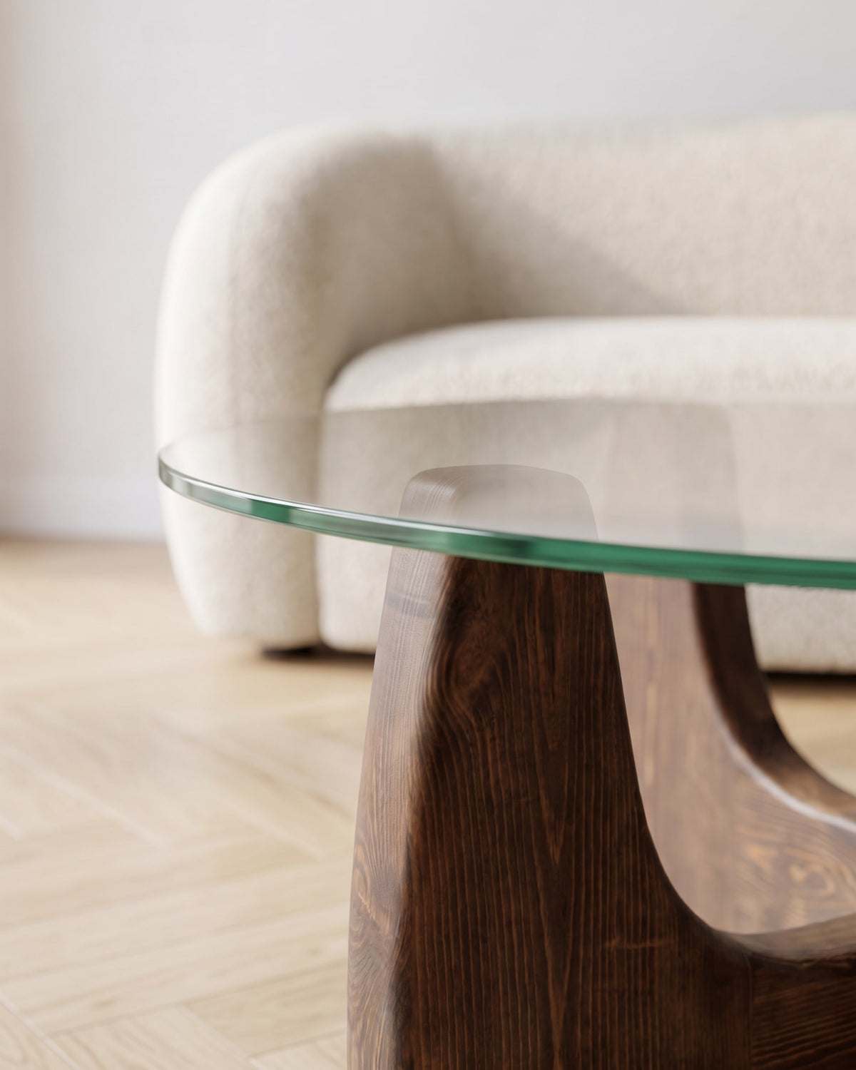 Close-up of the round glass top resting on the walnut-finish wooden base of the Selene coffee table